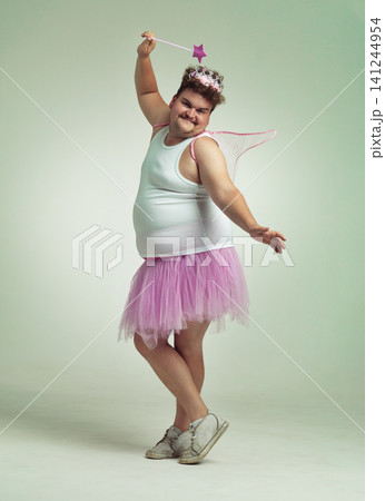 Funny, fairy and man in costume on studio with magic, wand and wings for plus size cosplay. Fantasy, character and creative model in dress up for role play on white background, mockup and space 141244954