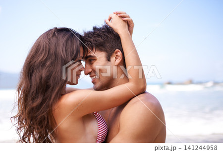 Love, hug and happy couple at ocean for tropical holiday adventure, relax and bonding together. Nature, man and woman smile on romantic date with beach, blue sky and embrace on vacation with mockup Love, hug and happy couple at ocean for tropical holiday adventure, relax and bonding together. Nature, man and woman smile on romantic date with beach, blue sky and embrace on vacation with mockup 141244958