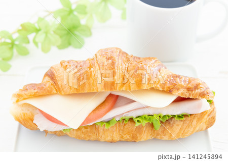 おいしいロースハムと新鮮野菜とモッツァレラのクロワッサンサンドとコーヒーのモーニング おいしいロースハムと新鮮野菜とモッツァレラのクロワッサンサンドとコーヒーのモーニング 141245894