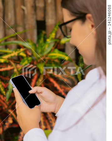 Woman using smartphone outdoor in natural setting 141246088