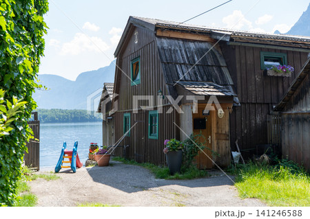 Traditional Wooden Boathouse on Hallstatt Lake Shore with Mountains and Kids Slide in Austria Europe Traditional Wooden Boathouse on Hallstatt Lake Shore with Mountains and Kids Slide in Austria Europe 141246588