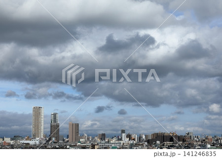 雨上がりの雲の間から青空が覗く都市風景とビル群 雨上がりの雲の間から青空が覗く都市風景とビル群 141246835