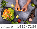 Hands peeling cooked shrimp for a seafood meal 141247286