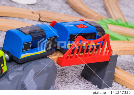 Train on plastic bridge with wooden toy tracks Train on plastic bridge with wooden toy tracks 141247330
