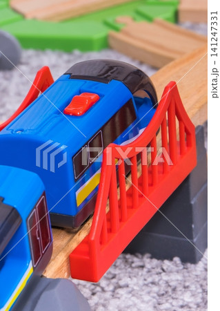 Train on plastic bridge with wooden toy tracks Train on plastic bridge with wooden toy tracks 141247331