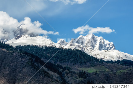 Mount Ushba with dramatic cloud formations and a dense pine forest in the foreground, Mount Ushba with dramatic cloud formations and a dense pine forest in the foreground, 141247344