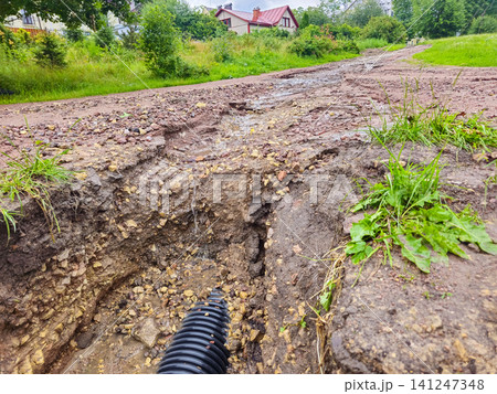 deep soil erosion on a rural road after heavy rainstorm deep soil erosion on a rural road after heavy rainstorm 141247348