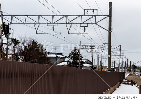 鉄道の架線柱と電気設備 鉛色の空と雪景色の沿線風景 鉄道の架線柱と電気設備 鉛色の空と雪景色の沿線風景 141247547