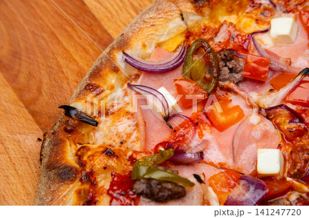 Close-up of pizza with various toppings on wooden cutting board 141247720