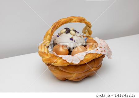 Braided bread basket with decorated Easter eggs and sweet bread Braided bread basket with decorated Easter eggs and sweet bread 141248218