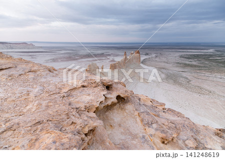 Rocky desert landscape with unique formations under cloudy sky Rocky desert landscape with unique formations under cloudy sky 141248619