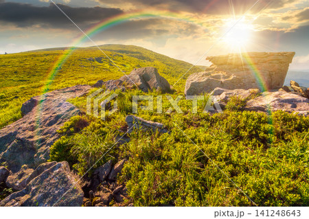 sunset over mountain landscape in summer. beautiful outdoor scenery of carpathian mountains. grassy slopes with rocks. image for ukraine travel background. weather with rainbow sunset over mountain landscape in summer. beautiful outdoor scenery of carpathian mountains. grassy slopes with rocks. image for ukraine travel background. weather with rainbow 141248643