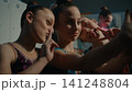 Three Young Gymnasts Making Funny Selfie on Smartphone Backstage 141248804
