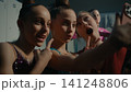 Three Young Gymnasts Making Funny Selfie on Smartphone Backstage 141248806