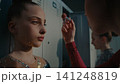 Teen Female Athletes Doing Makeup in Modern Locker Room 141248819