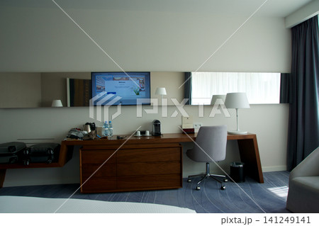 Wroclaw, Poland, June 15, 2018: Sideboard with desk chair and wall mounted TV in luxury hotel room Wroclaw, Poland, June 15, 2018: Sideboard with desk chair and wall mounted TV in luxury hotel room 141249141