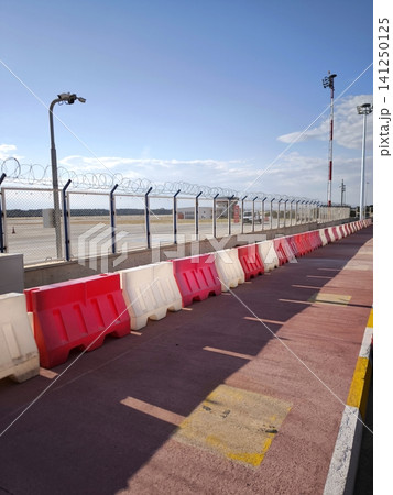 Red and white plastic road safety barriers at the airport. 141250125