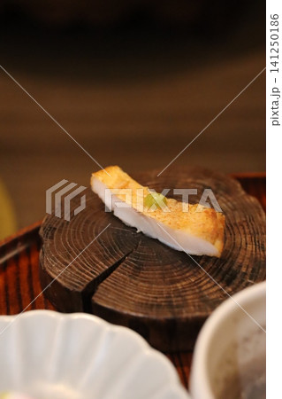Sliced Fish with Pea Garnish on Wooden Log 141250186