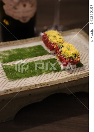 Sushi Rolls with Green Garnish on Decorative Plate 141250197