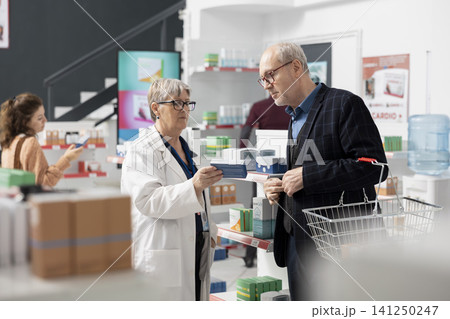 Female drugstore professional helping senior customer understand medication directions. Caucasian woman pharmacist confidently recommends suitable healthcare products, providing guidance with care. Female drugstore professional helping senior customer understand medication directions. Caucasian woman pharmacist confidently recommends suitable healthcare products, providing guidance with care. 141250247