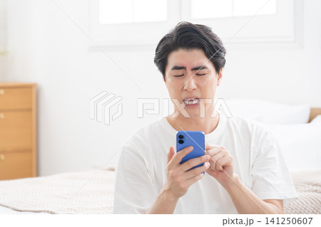 スマホを見る男性 スマホを見る男性 141250607