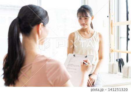 ピラティススタジオで話を聞く女性 ピラティススタジオで話を聞く女性 141251320
