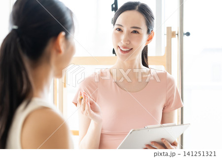 ピラティススタジオで話を聞く女性 ピラティススタジオで話を聞く女性 141251321