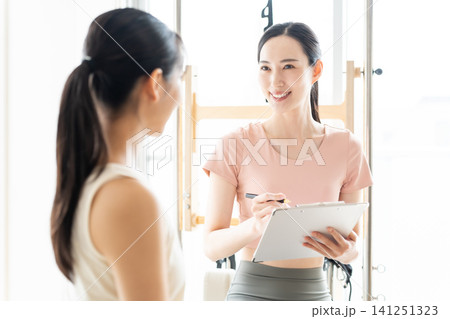 ピラティススタジオで話を聞く女性 ピラティススタジオで話を聞く女性 141251323