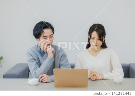 ダイニングでパソコンを見る夫婦 141251445