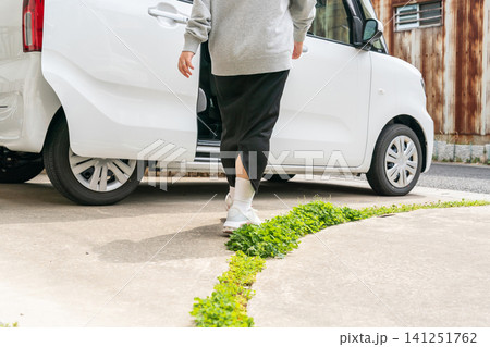 庭に駐車した車のスライドドアを開ける女性 庭に駐車した車のスライドドアを開ける女性 141251762