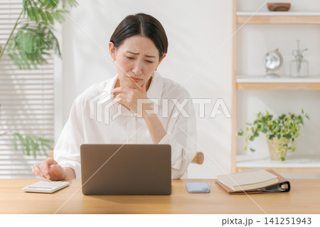 頭を抱える40代女性 頭を抱える40代女性 141251943