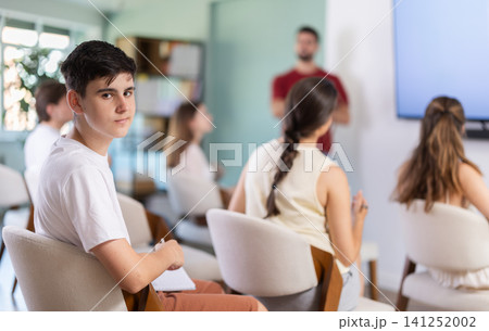 Guy listens and watches a lecture presentation 141252002