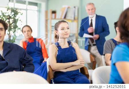 Mature male lecturer in background of classroom, address to young employee listeners. Mature male lecturer in background of classroom, address to young employee listeners. 141252031