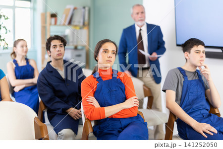 Mature male lecturer in background of classroom, address to young employee listeners. Mature male lecturer in background of classroom, address to young employee listeners. 141252050