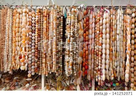 Beads from various semi-precious stones at the stand of jewelry store 141252071