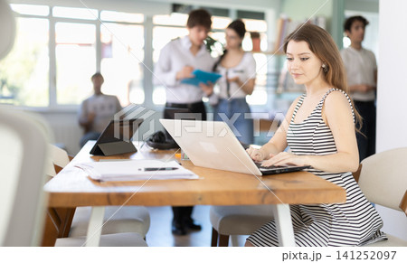 Young woman working on laptop in modern office Young woman working on laptop in modern office 141252097