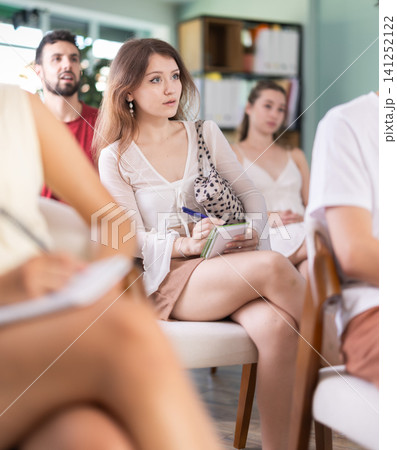 At meeting room during lecture, girl visitor listen to teacher At meeting room during lecture, girl visitor listen to teacher 141252122