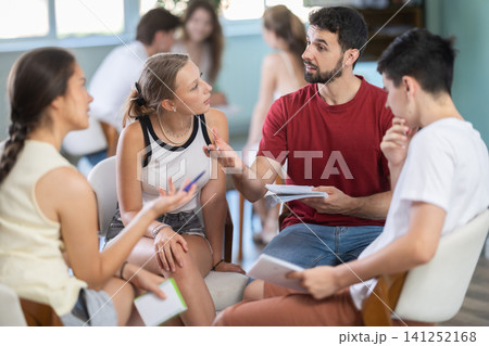 Students have divided into two teams and are discussing tactics of debate or competition Students have divided into two teams and are discussing tactics of debate or competition 141252168