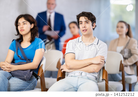 Young students sit in the auditorium and listen to a lecture 141252212