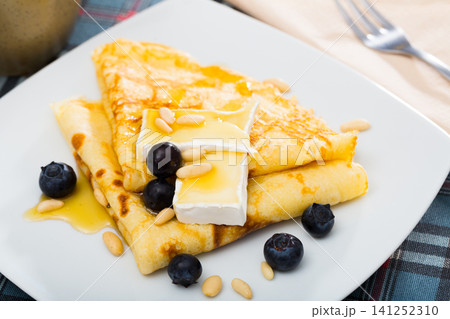 Appetizing pancakes with cheese, honey and nuts 141252310