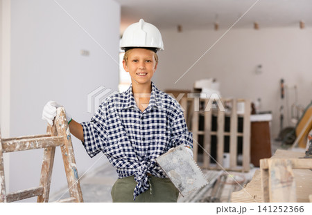 Portrait of young cheerful boy in construction site 141252366