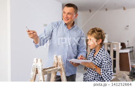 Man showing son blueprints in new home 141252664