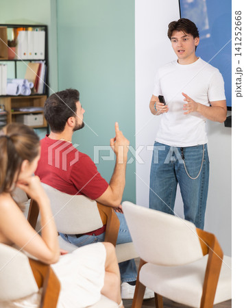 teacher stands near a screen and gives a lecture to students teacher stands near a screen and gives a lecture to students 141252668