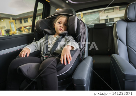preschool child girl sitting in car seat, safety baby chair travelling preschool child girl sitting in car seat, safety baby chair travelling 141253071