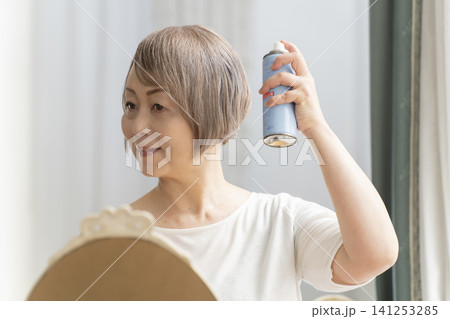 スプレーでヘアスタイルを整えるシニア女性 141253285