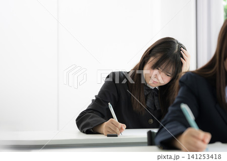 テストや受験勉強に悩む考える日本人女子高校生 受験のプレッシャーと学習ストレスと試験対策のイメージ テストや受験勉強に悩む考える日本人女子高校生 受験のプレッシャーと学習ストレスと試験対策のイメージ 141253418