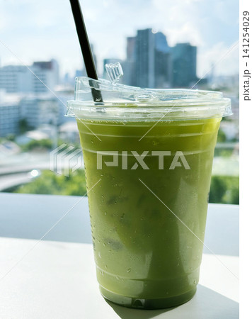 Close-up of a refreshing iced pure matcha green tea in a plastic takeaway cup 141254029