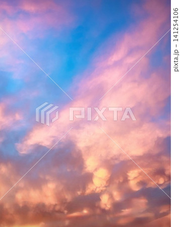 夏の夕暮れに広がるピンクとブルーの幻想的なグラデーションの夕焼け空と雲 141254106