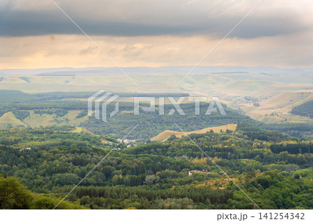 Layers of green mountains and hills in the haze during sunset. Panoramic View of Green hills and Meadow. Layers of green mountains and hills in the haze during sunset. Panoramic View of Green hills and Meadow. 141254342