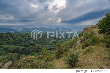 A mountain range covered in the wild woods illuminated by the golden light of the setting sun. A natural Park reserve or hunting grounds. Recreational outdoor tourism 141254368